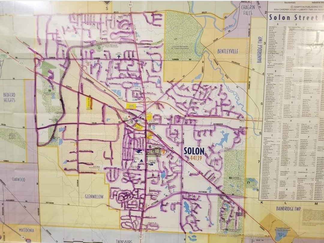 A paper street map of Solon with nearly every road traced over by hand in purple marker