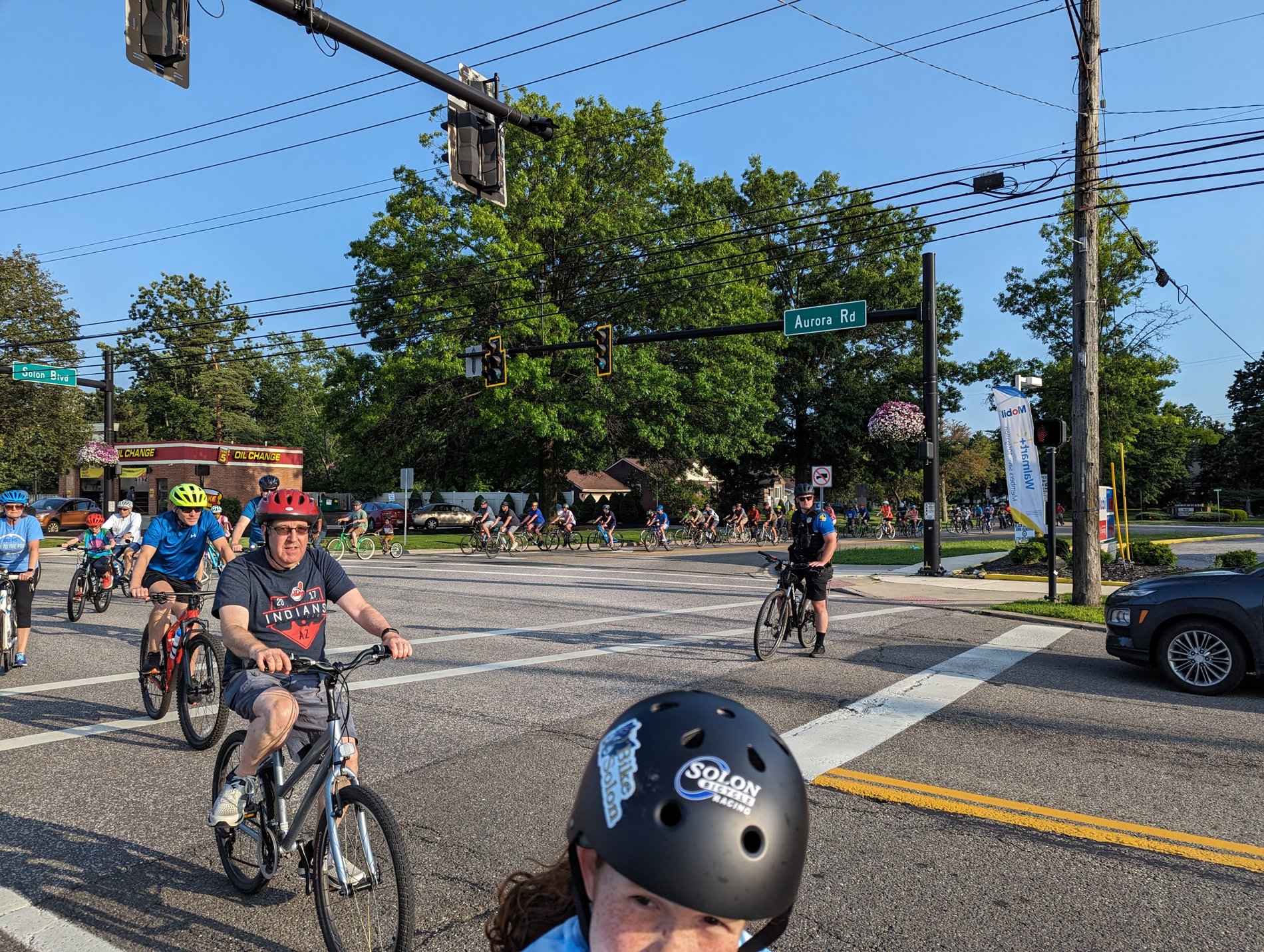 A police escort leads Bike With a Mayor riders through the Aurora Road intersection in Solon