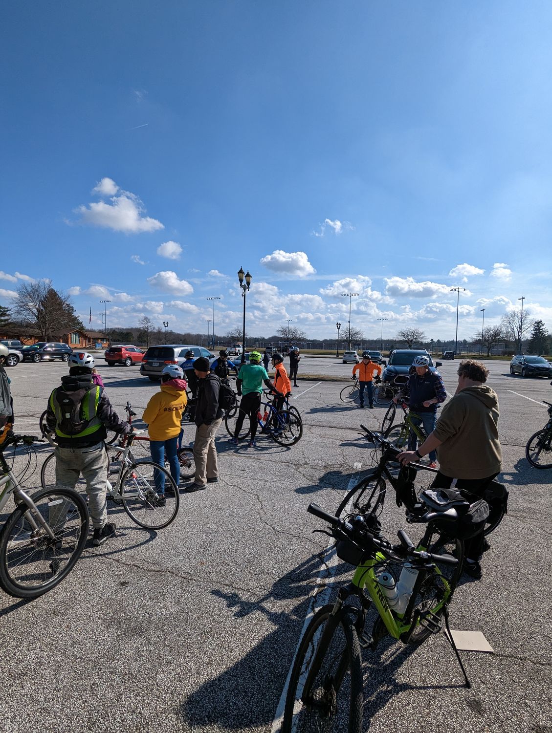 Riders gathering with their bikes under a bright sky before a Bike Solon community ride